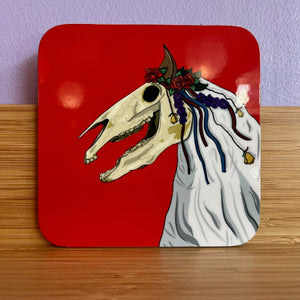 Decorative coaster with a horse skull design on a red background