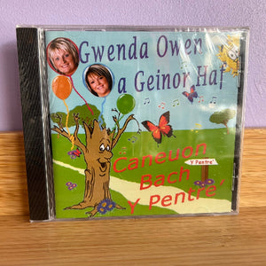 CD cover with a tree, butterflies, and text on a wooden surface