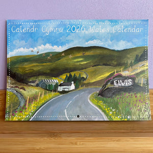 Wales calendar with a scenic design on a wooden surface and purple wall background