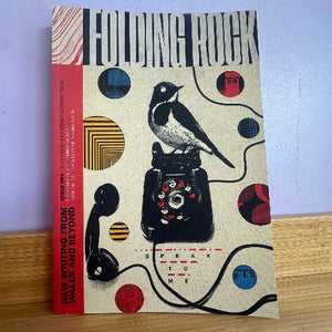 Book titled 'Folding Rock' with a design of a bird and vintage phone on a wooden surface.