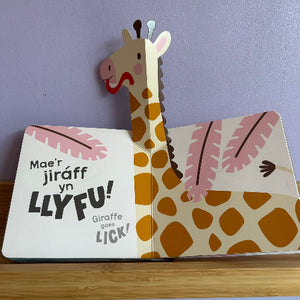 Children's book with a giraffe illustration and text on a wooden surface.