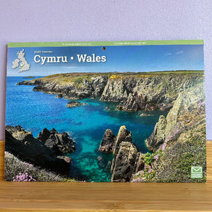 Calendar cover featuring a scenic view of Wales with cliffs and blue water.