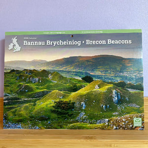 Calendar cover featuring a scenic view of the Brecon Beacons with a green border and 'Bannau Brycheiniog' text.