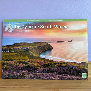 Calendar cover featuring a scenic view of South Wales with a beach and cliffs.