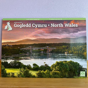 Calendar cover featuring a scenic view of North Wales with a bridge over water and mountains in the background.