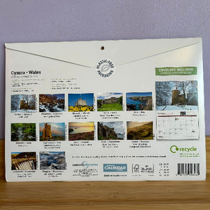 Calendar packaging with images of Wales on a wooden surface and light purple wall background
