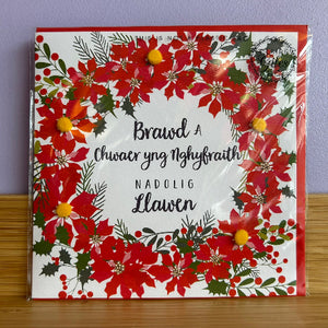 Christmas card with red floral design and Welsh text 