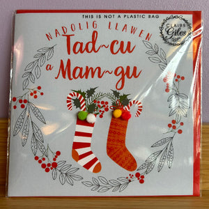 card with Christmas-themed design and text, featuring stockings and holly leaves.
