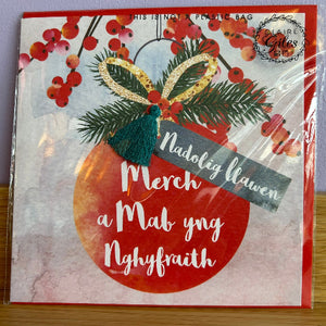 Card with Christmas-themed design and text, featuring a red ornament and festive elements.