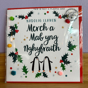Christmas-themed product packaging with holly leaves and penguins on a white background.