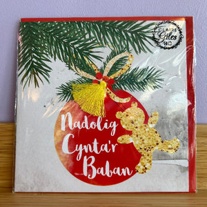 Christmas card with a red ornament and gold teddy bear on a white background