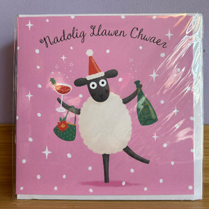 Card with a sheep illustration holding a bottle and glass on a pink background with white polka dots.