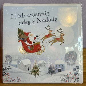 Christmas card with Santa Claus in a sleigh, reindeer, and snowy village scene.