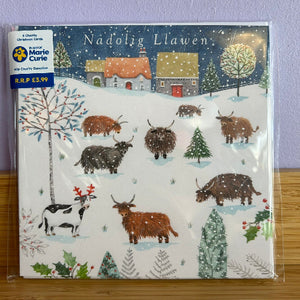 Pack of Christmas cards with Highland cows and trees on a snowy landscape, featuring the Marie Curie charity logo.