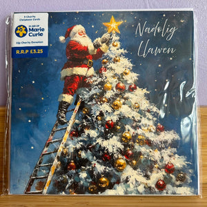 Christmas card with Santa Claus decorating a tree, featuring Marie Curie charity logo.