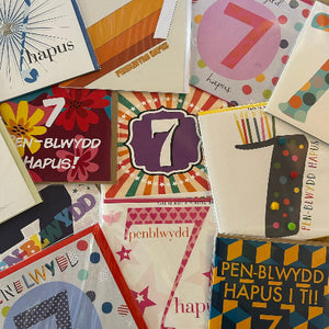 Collection of colorful greeting cards with numbers '7' and text, likely for a seventh birthday celebration.