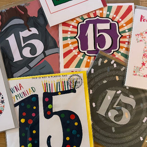 Collection of greeting cards with the number 15 on them, featuring various designs and colors.