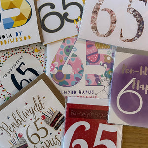 Collection of greeting cards with the number '65' on them, featuring various designs and text.