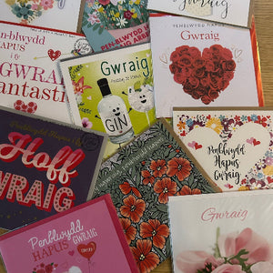 Collection of greeting cards with various designs and text on a wooden surface