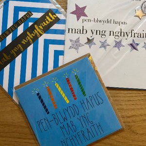 Collection of greeting cards with celebratory designs on a wooden surface