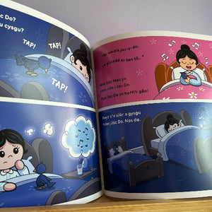Open book with cartoon illustrations of a child in bed and an owl, on a wooden surface.
