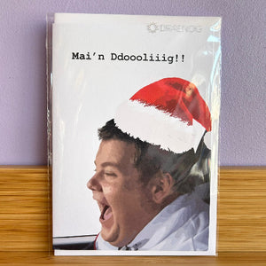 Packaged card with a person wearing a Santa hat and text on a purple wall background