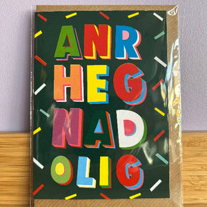 Colorful greeting card with abstract text design on a wooden surface.