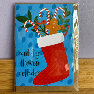 Christmas card with a red stocking, gingerbread man, and candy canes on a blue background.