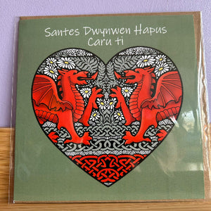 Card with red dragons in a heart shape on a green background