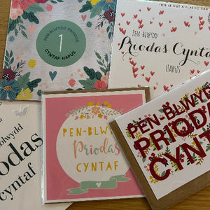 Collection of greeting cards with floral and text designs on a wooden surface