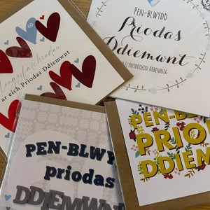 Collection of greeting cards with different designs and text on a wooden surface
