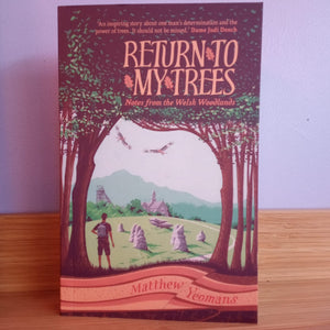 Book cover of 'Return to My Trees' by Matthew Yeomans on a wooden surface with a light purple wall background.