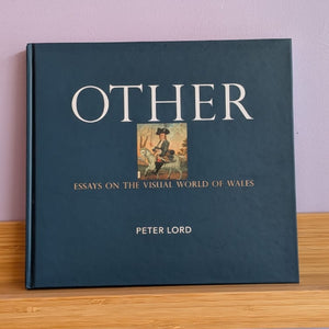 A hardcover book titled 'OTHER' by Peter Lord, featuring a dark teal cover with white lettering and a small central illustration, displayed on a light wood shelf against a lavender wall.