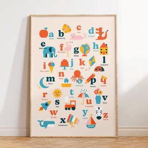 Framed alphabet poster with colorful letters and illustrations on a white wall.