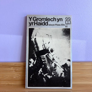 Book with black and white design on a wooden surface against a purple wall