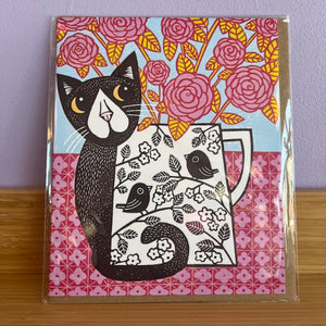 Greeting card with a black cat and floral design on a pink and yellow floral background