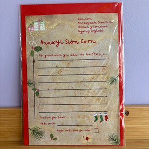 Decorative letterhead with Christmas-themed design on a red border, against a light purple wall.