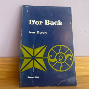 Book titled 'Ifor Bach' by Ivor Owen with a blue cover and yellow text and designs on a wooden surface.