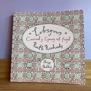 Decorative book with a patterned cover and text on a wooden surface and purple wall background