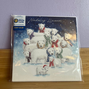 Packaged Christmas card with polar bears wearing scarves on a wooden surface.