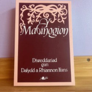 Book titled 'Mabinogion' with decorative text on a wooden surface